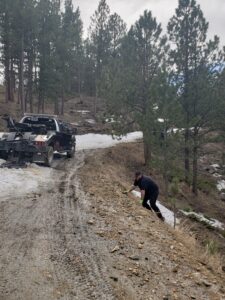 Person trying to tow a car on a hill side